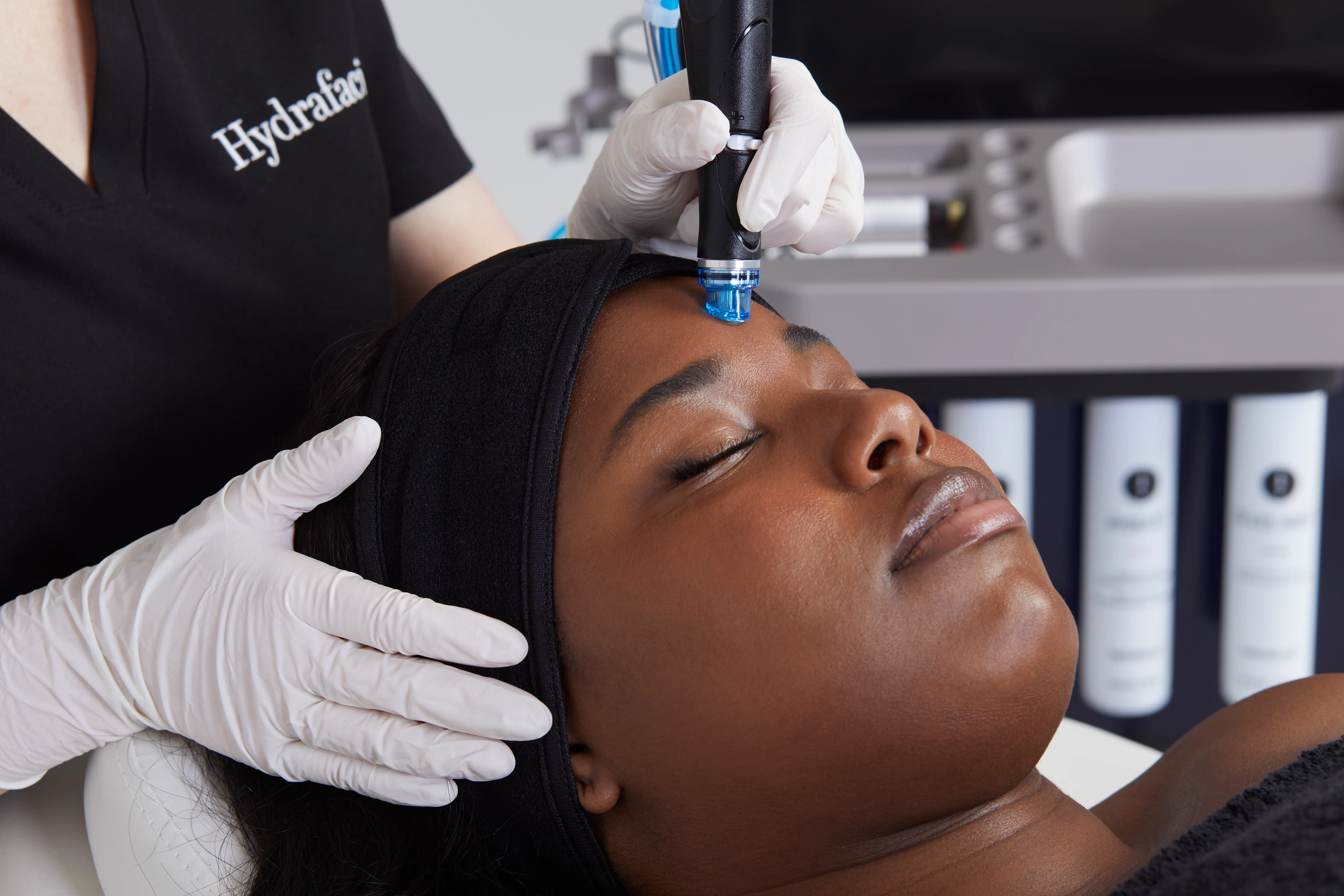Skin therapist Lana performing a HydraFacial hydradermabrasion treatment on a patient at Rejuvena Clinic in Bedford