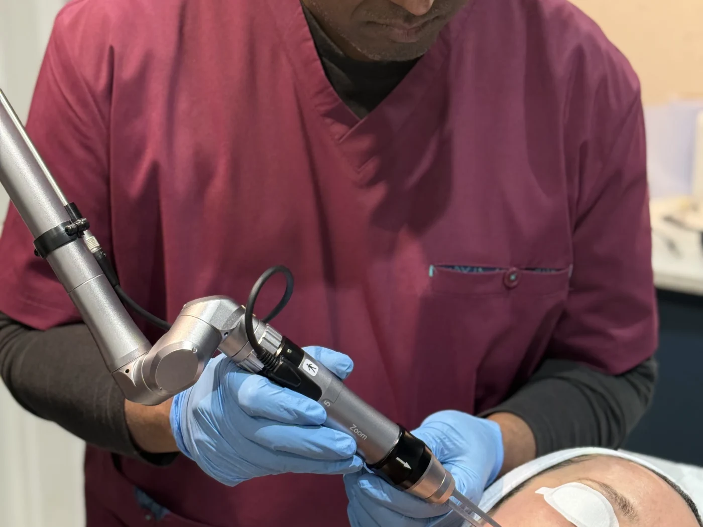 Practitioner delivering picosecond laser pico toning with a handheld device, patient wearing protective eyewear, at Rejuvena Clinic in Bedford