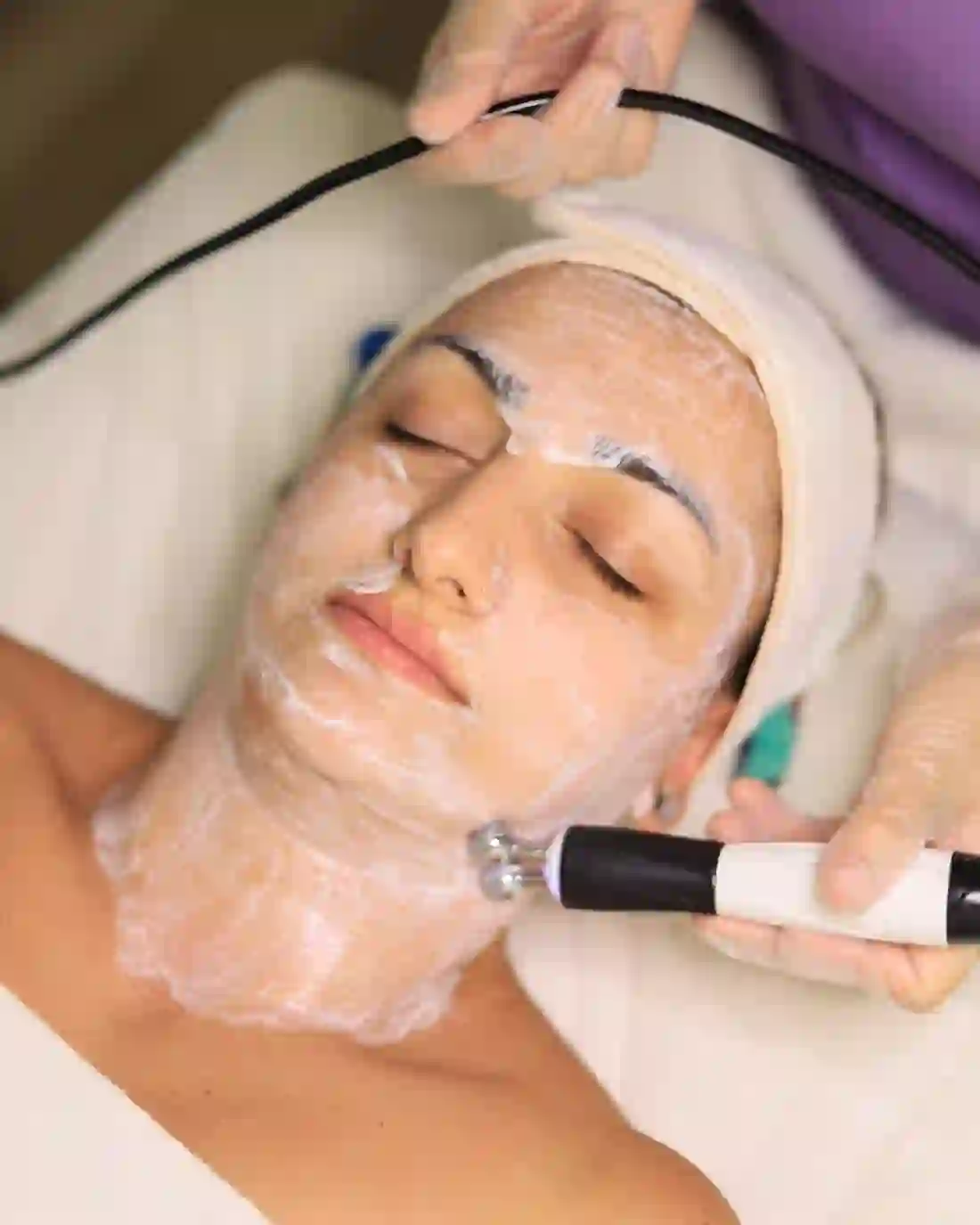 Illustrative photo of a radiofrequency and electromagnetic skin-tightening applicator being glided over the jawline and neck — the same non-invasive mechanism used for EndoContour at Rejuvena Bedford