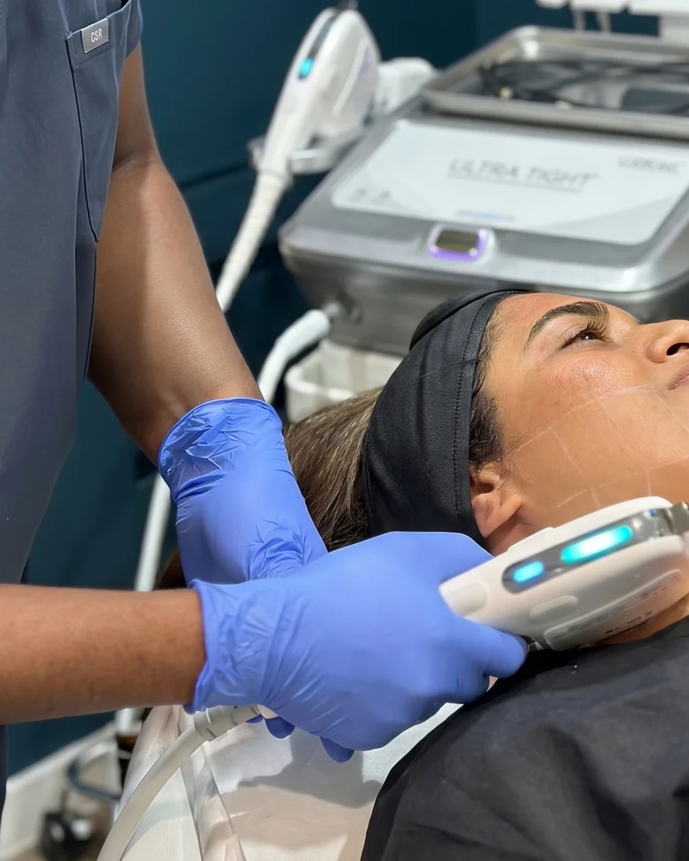A clinician performing a doctor-led HIFU ultrasound lift on a patient’s jawline with the Ultra Tight device at Rejuvena Clinic, Bedford