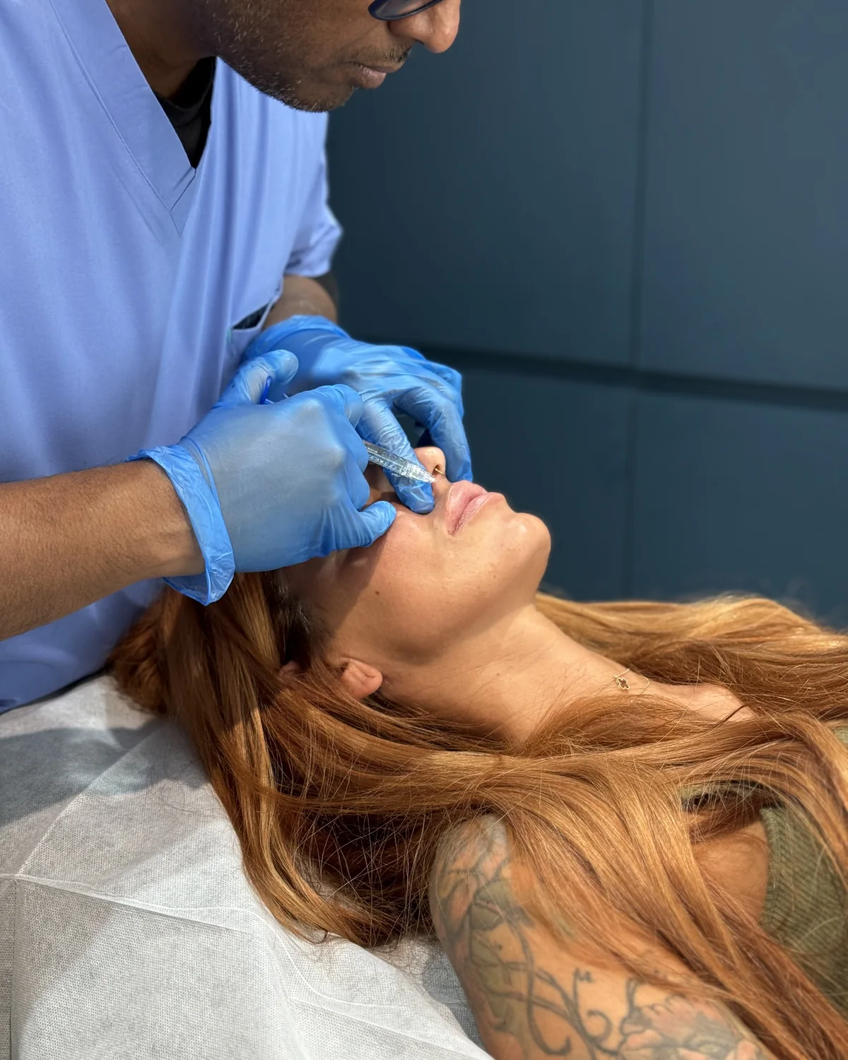 Dr Nick injecting hyaluronic acid lip filler with a fine needle during a doctor-led treatment at Rejuvena Clinic, Bedford