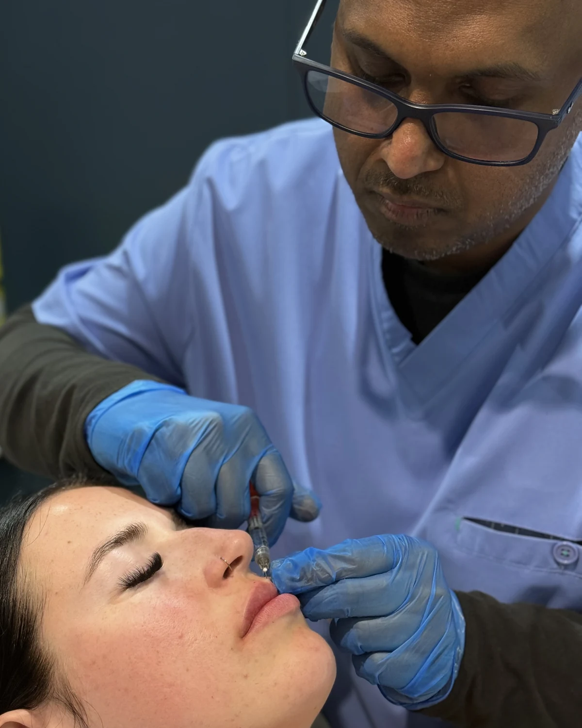Dr Nick injecting hyaluronic acid lip filler with a fine needle during a doctor-led treatment at Rejuvena Clinic, Bedford