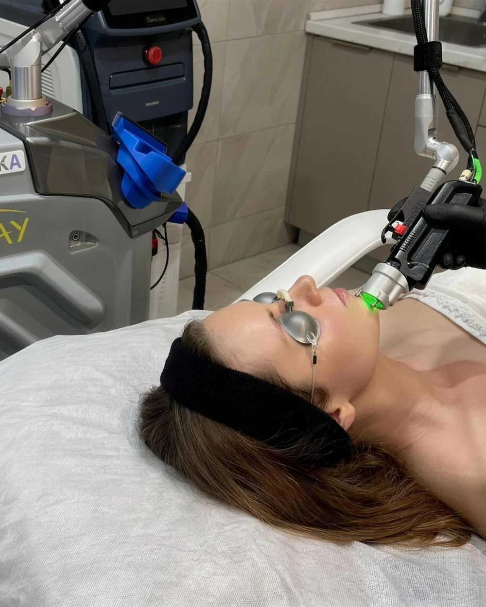 A patient receiving a doctor-led MoveoGlo&reg; laser facial with the Lynton Motus AY handpiece at Rejuvena Clinic, Bedford
