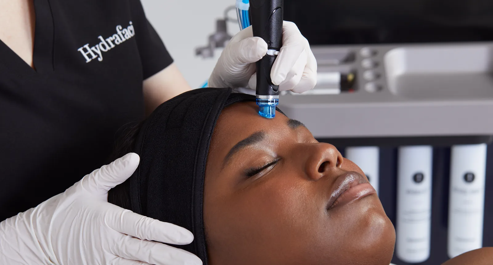 HydraFacial handpiece treating a patient's forehead during a hydradermabrasion facial (official HydraFacial image)