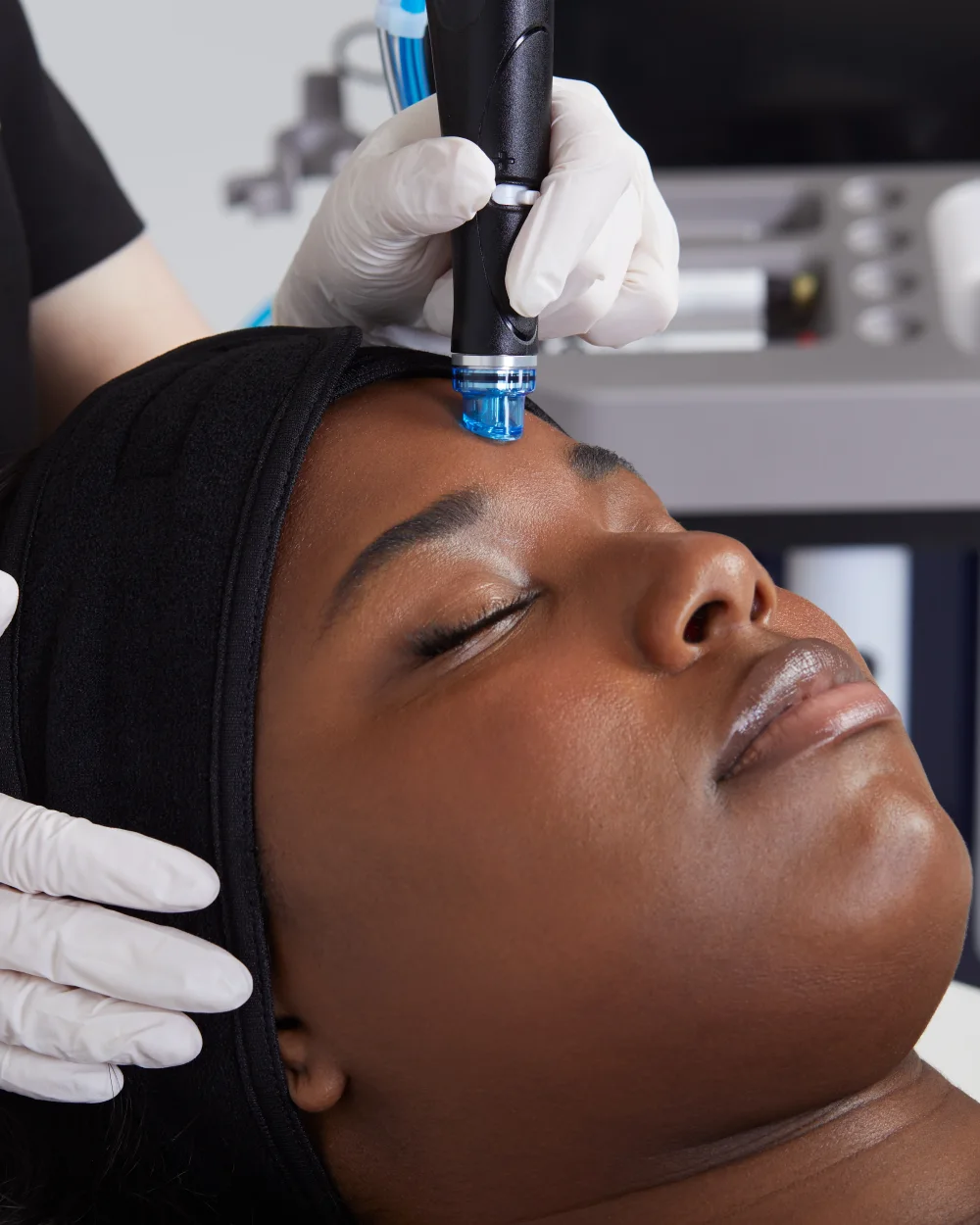 Patient receiving a professional in-clinic skin treatment in a clean clinical treatment room at Rejuvena Bedford