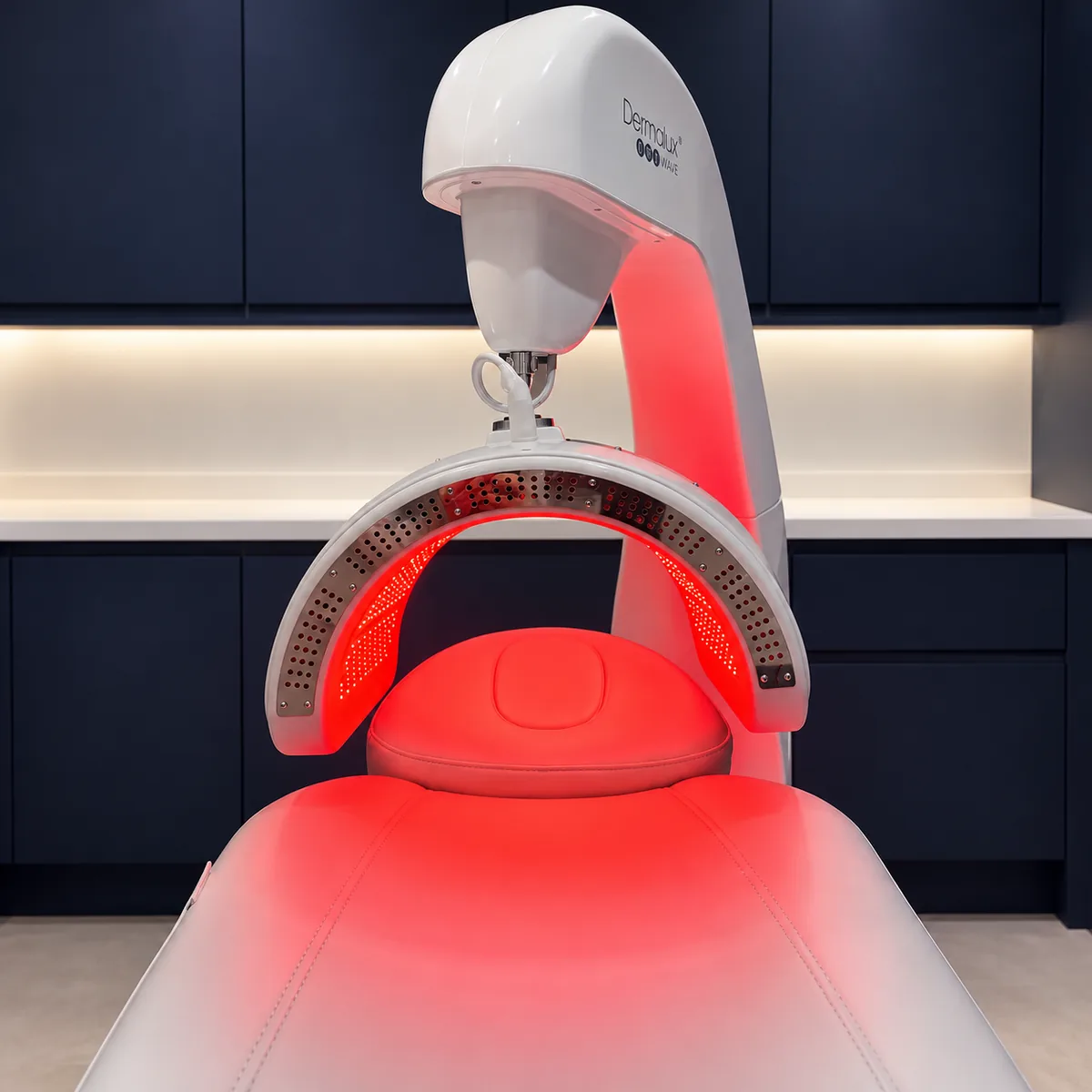 The Dermalux&reg; Triwave LED canopy glowing red over the treatment couch at Rejuvena Clinic, Bedford