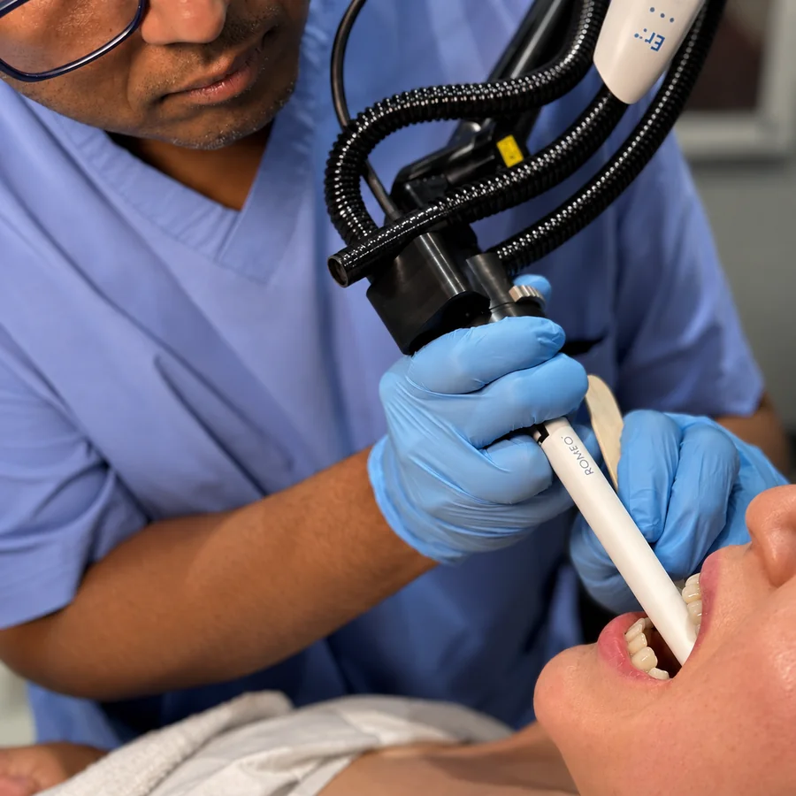 Dr Nick guiding the Romeo Er:YAG laser handpiece into a patient’s mouth during anti-snoring treatment at Rejuvena Clinic in Bedford